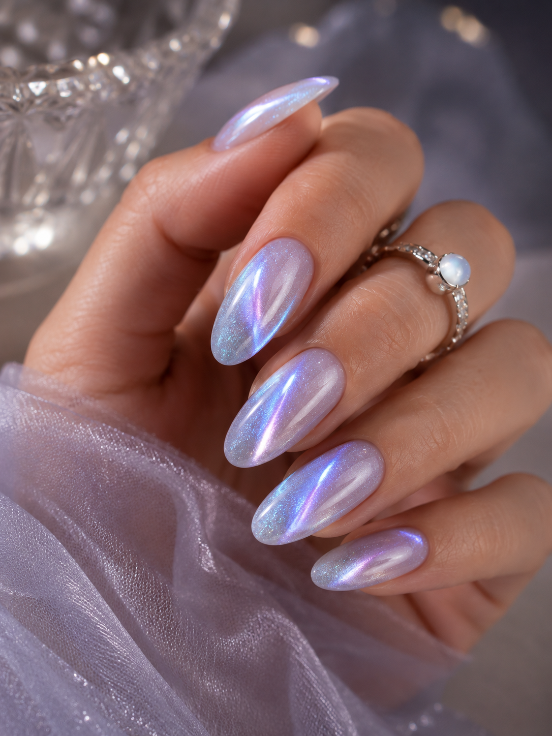 Moonstone-effect cat eye nails with an iridescent lavender and blue magnetic shimmer on almond-shaped nails
