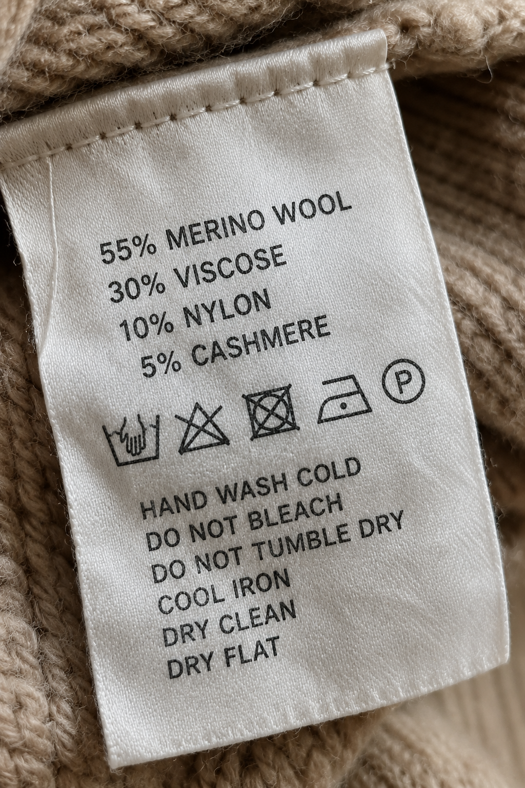 Close up of a clothing care label showing fiber content percentages inside a sweater